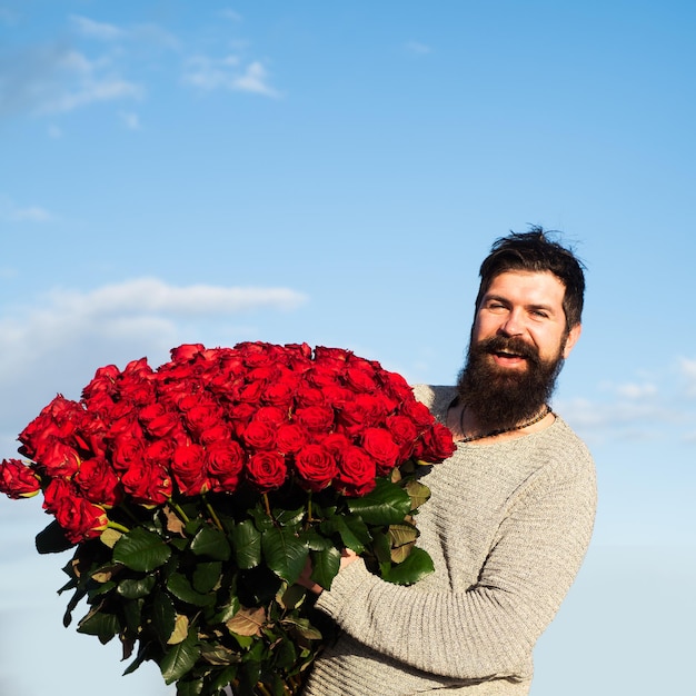 Man with bouquet of flowers happy man holds a large bouquet of red roses propose to boyfriend on dat