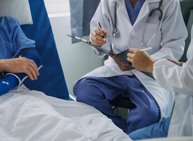 Man with broken arm in cast lying on bed in hospital The emergency center treatment is plaster and hangs with sling for a further cure in an orthopedic clinic Patient pain from accident injury