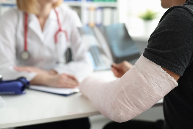 A man with a broken arm is sitting at the doctor blurry