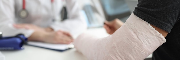 A man with a broken arm is sitting at the doctor blurry