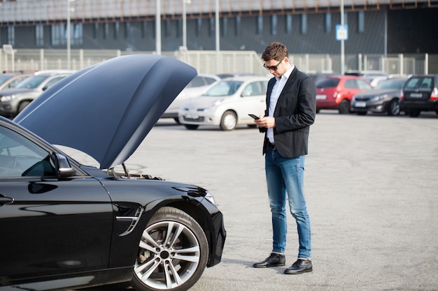 Man with broken car in the middle of the road