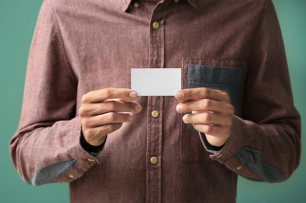 Photo man with business card on color background, closeup