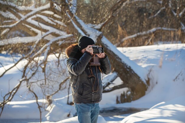 a man with a camera takes pictures of winter nature