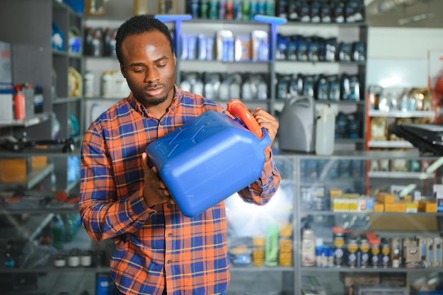 Photo man with canister of motor oil in auto store