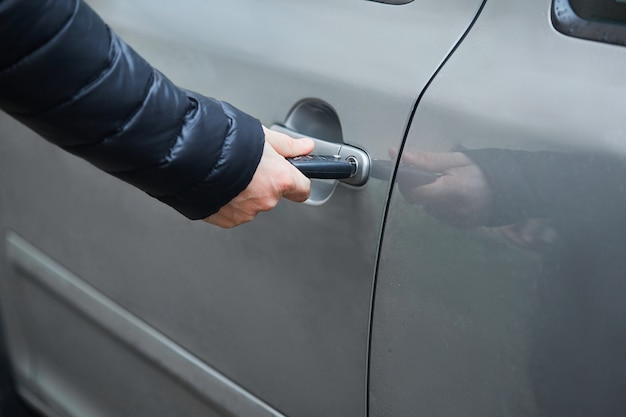 Man with car key opening car door