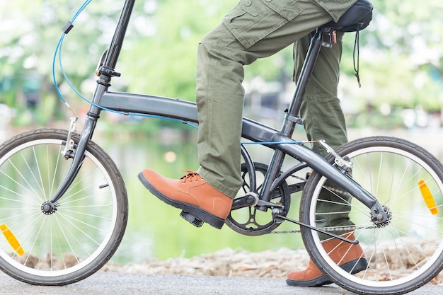 庭で自転車に乗ってカーゴパンツを持つ男