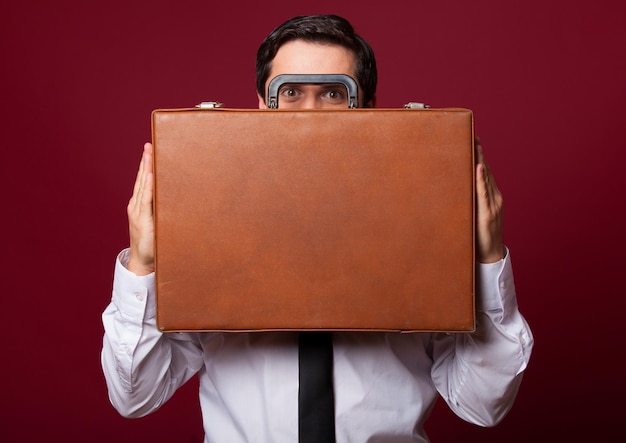 Man with case at red background