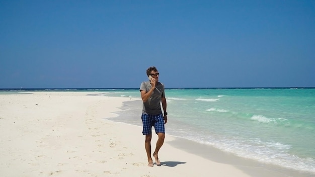 Man with a cell phone on the beach