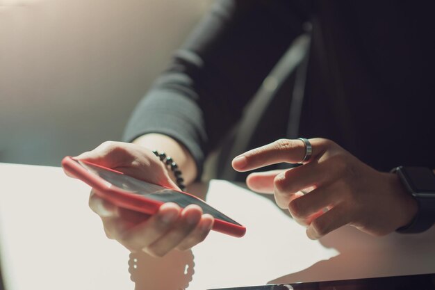 Foto uomo con un telefono cellulare in mano e appoggiato il dito indice su uno schermo vuoto