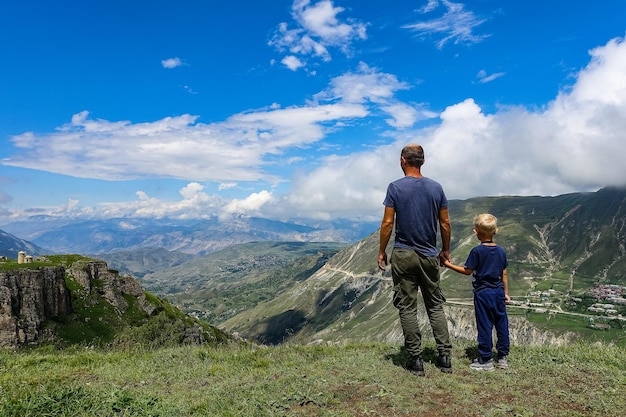 A man with a child on the background of a view of the Matlas plateau Khunzakhsky district Dagestan Russia 2021