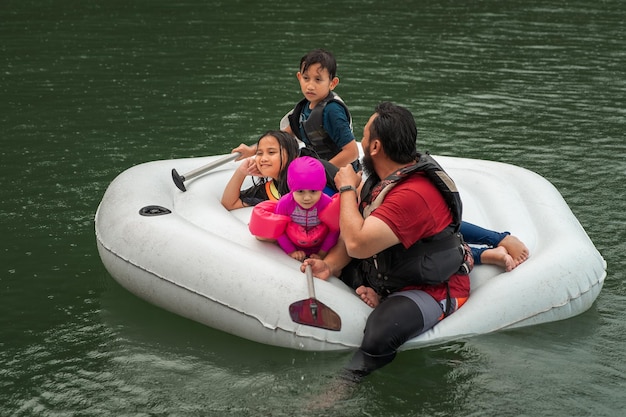 Photo man with children floating on lake