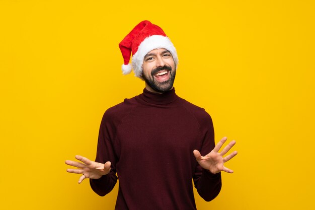 Man with christmas hat over isolated yellow background