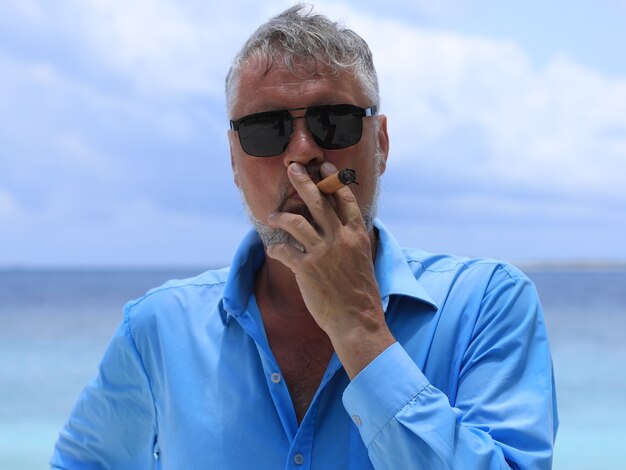 man with a cigar on a tropical island