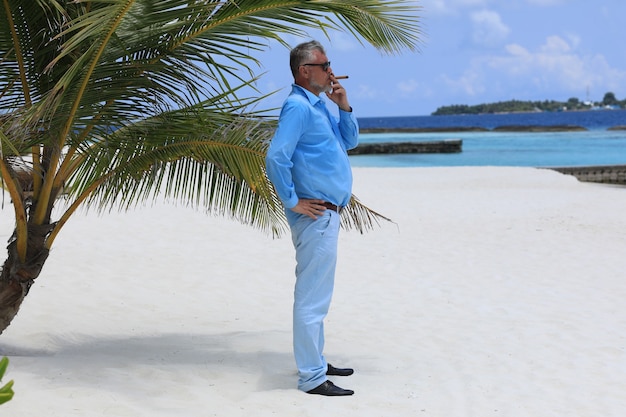 man with a cigar on a tropical island