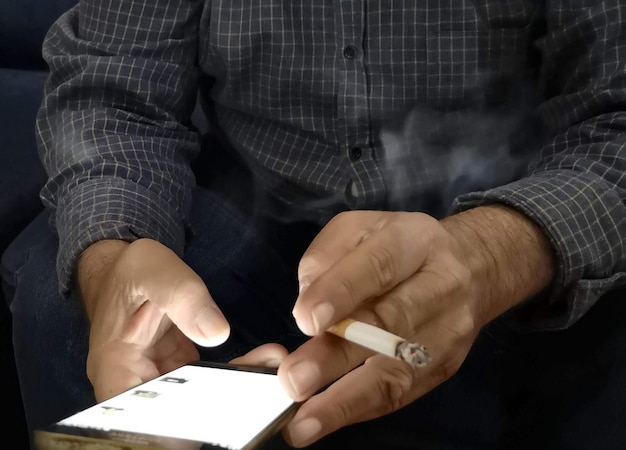 インターネット画像で苦しんでいる指の間にタバコを持った男性