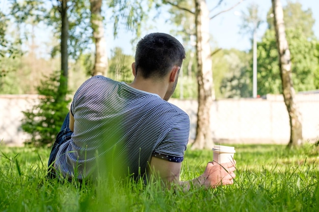 Uomo con caffè nel parco