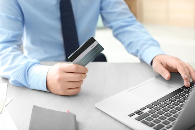 Photo man with credit card and laptop at table