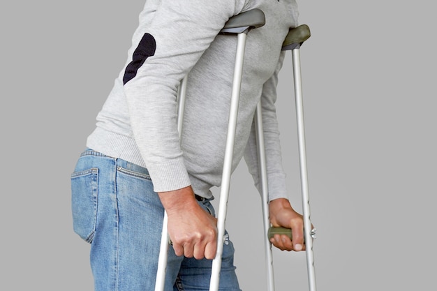 Man with crutch. Close-up. Side view