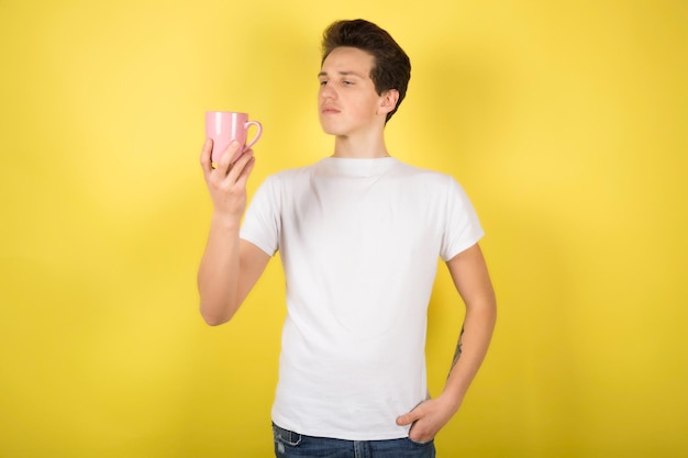 Man with cup of coffee on yellow background