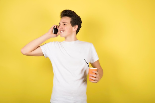 Man with cup of coffee on yellow background