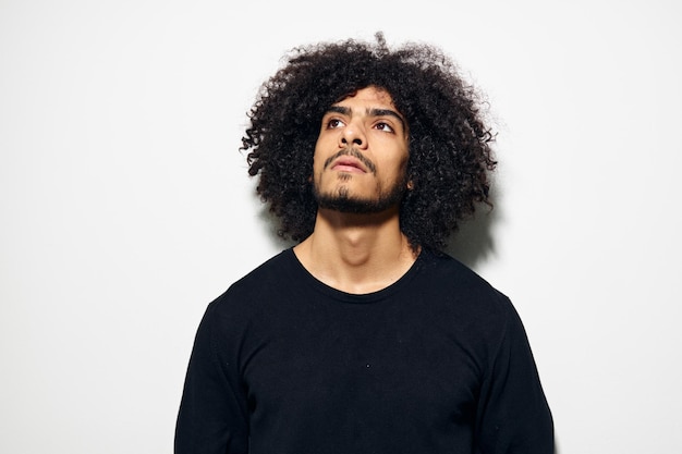 Man with curly hair in a black sweater hand gesture Lifestyle unaltered