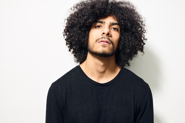 Man with curly hair in a black sweater hand gesture Lifestyle unaltered