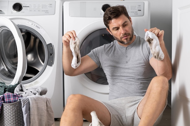 洗濯機の汚れた洗濯物フロントを持つ男