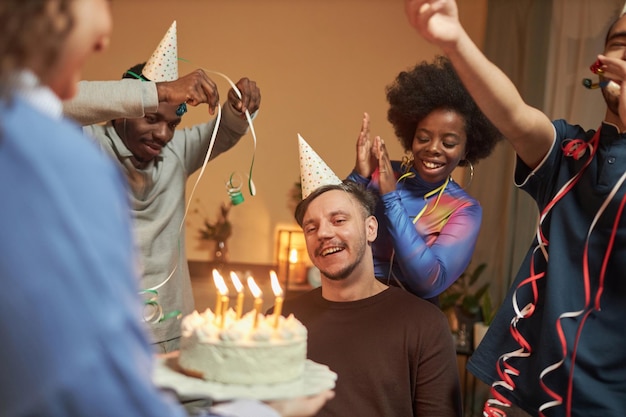 障害のある男性が誕生日を祝いろうそくを吹き飛ばしています