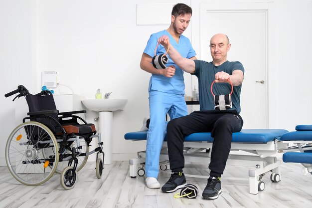Photo man with disability doing recovery exercise with dumbbell man with ataxy in recovery support therapy...