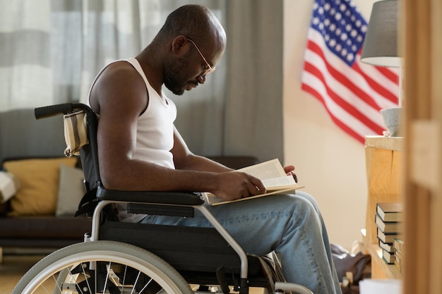 Foto uomo con disabilità che legge un libro