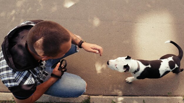 Фото Человек с собакой, присевшим на тропинке