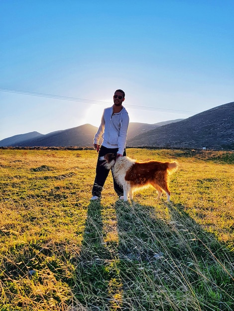 Foto uomo con il cane sul campo contro il cielo