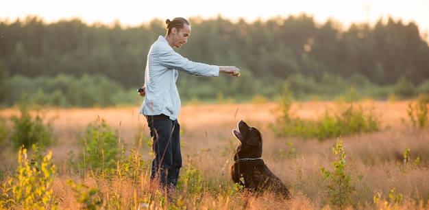 Photo man with dog standing on field