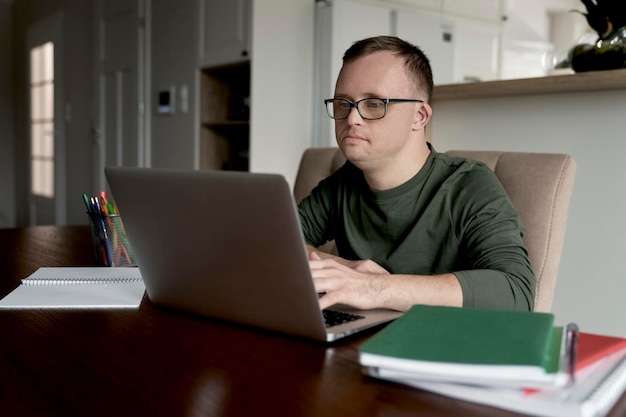 Man with down syndrome using laptop while studying at home