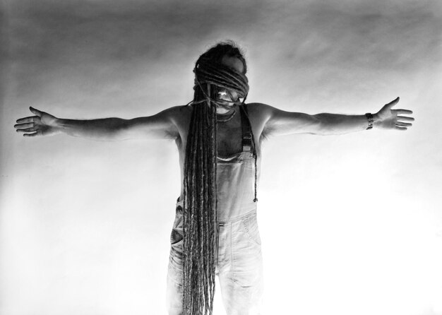 Photo man with dreadlocks standing against wall