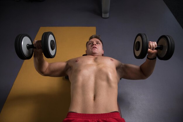 Photo man with dumbbells exercising chest