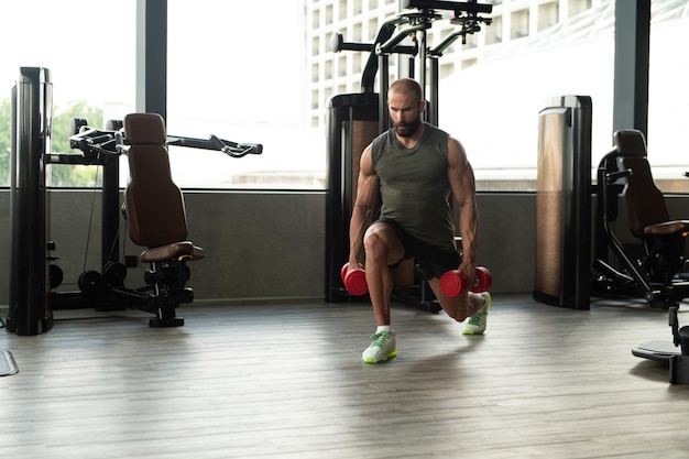 Man With Dumbbells Exercising Quadriceps And Glutes