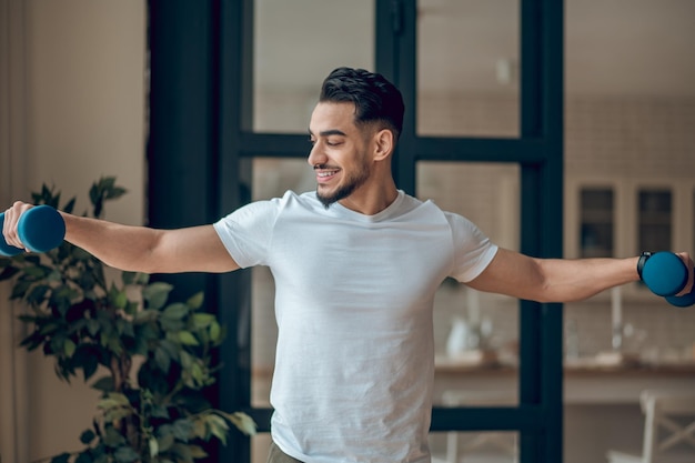 A man with dumbbells having a home workout