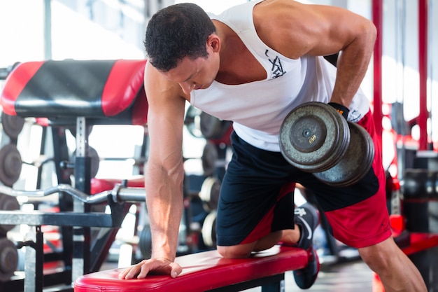 man with dumbbells at sport in fitness gym