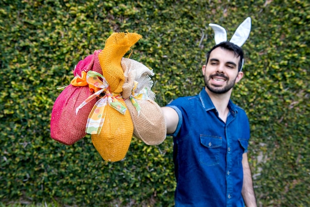 Man with easter bunny ears holding easter eggs selective focus