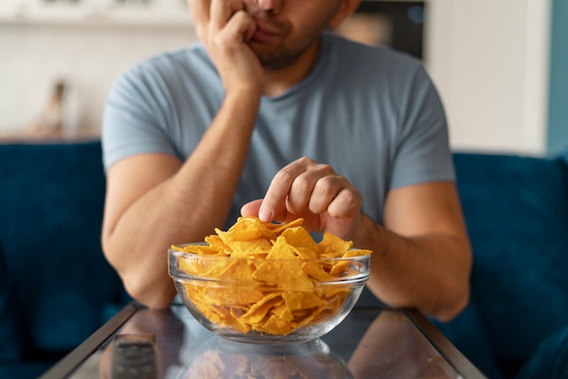 Man with eating disorder trying to eat chips