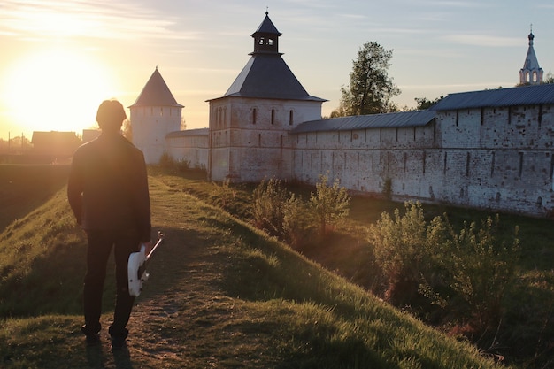 A man with an electric guitar in the industrial landscape outdoors