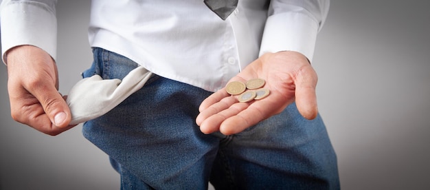 Man with a empty pocket showing coins