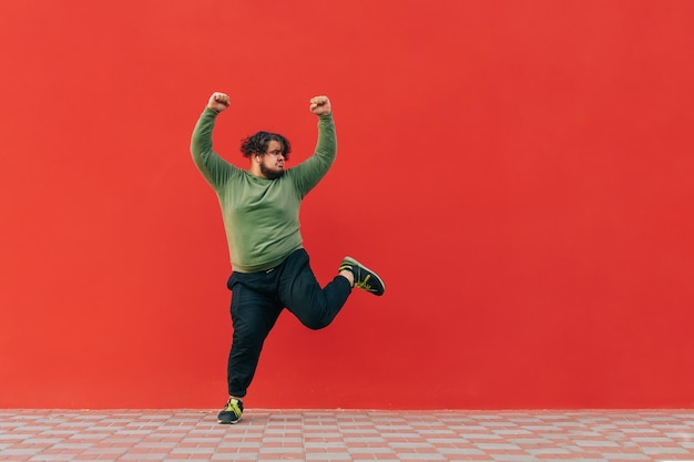 Photo man with excess weight dances funny dances