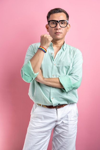 Man with eyeglasses and a shirt showing a rainbow bracelet