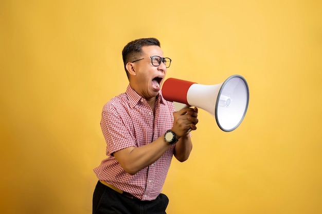 Man with eyeglasses and a shirt talking on a megaphone