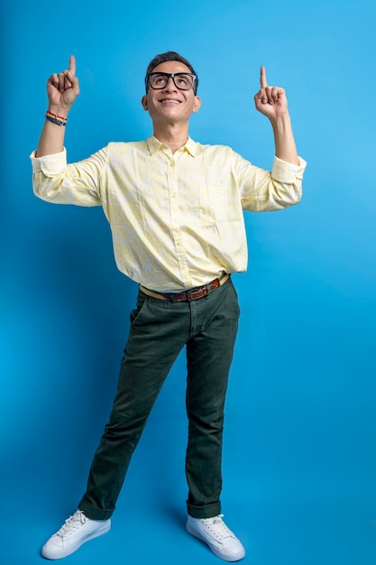Man with eyeglasses and a shirt wearing a rainbow bracelet pointing at something