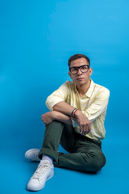 Man with eyeglasses and a shirt wearing a rainbow bracelet