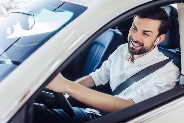 Man with fasten safety belt driving a car