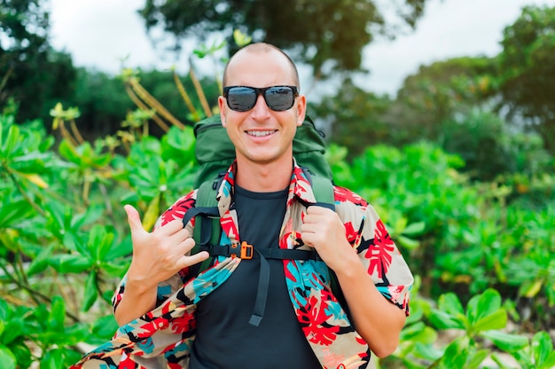 Man with flower shirt and backpack